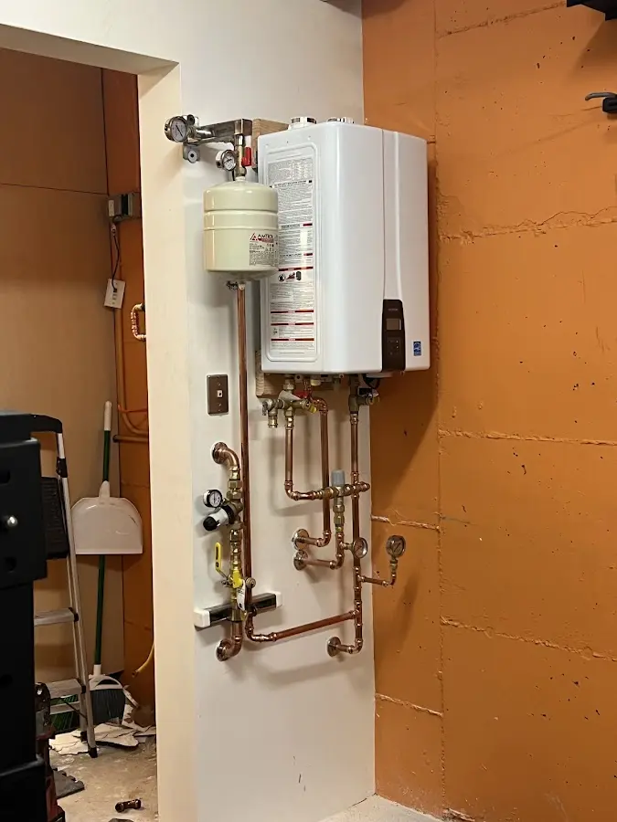 Plumbing technician inspecting water heater connections in Summit